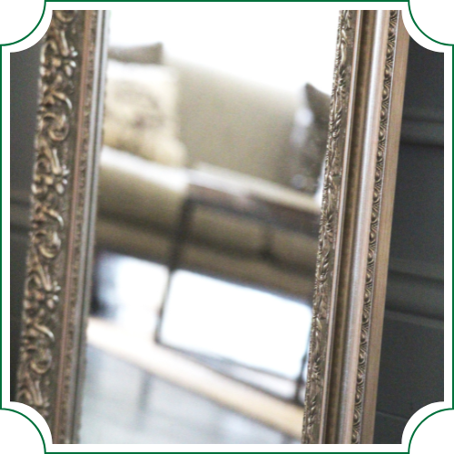 close up of mirror in silver frame with intricate detail