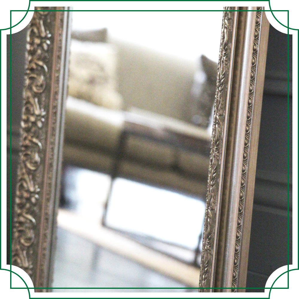 a close up of an antique mirror with a silver frame