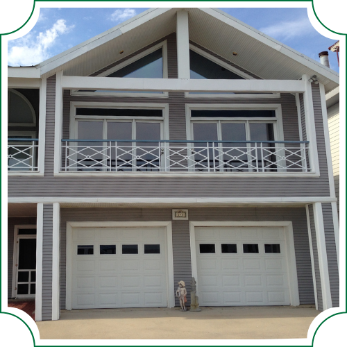 front of home with large glass windows on second floor